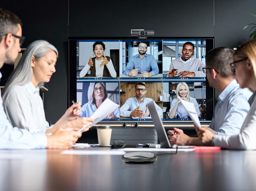 Team of 3 to 4 people using AVerMedia PW515 4K webcam and AS315 AI speakerphone for online meeting in a huddle room. 